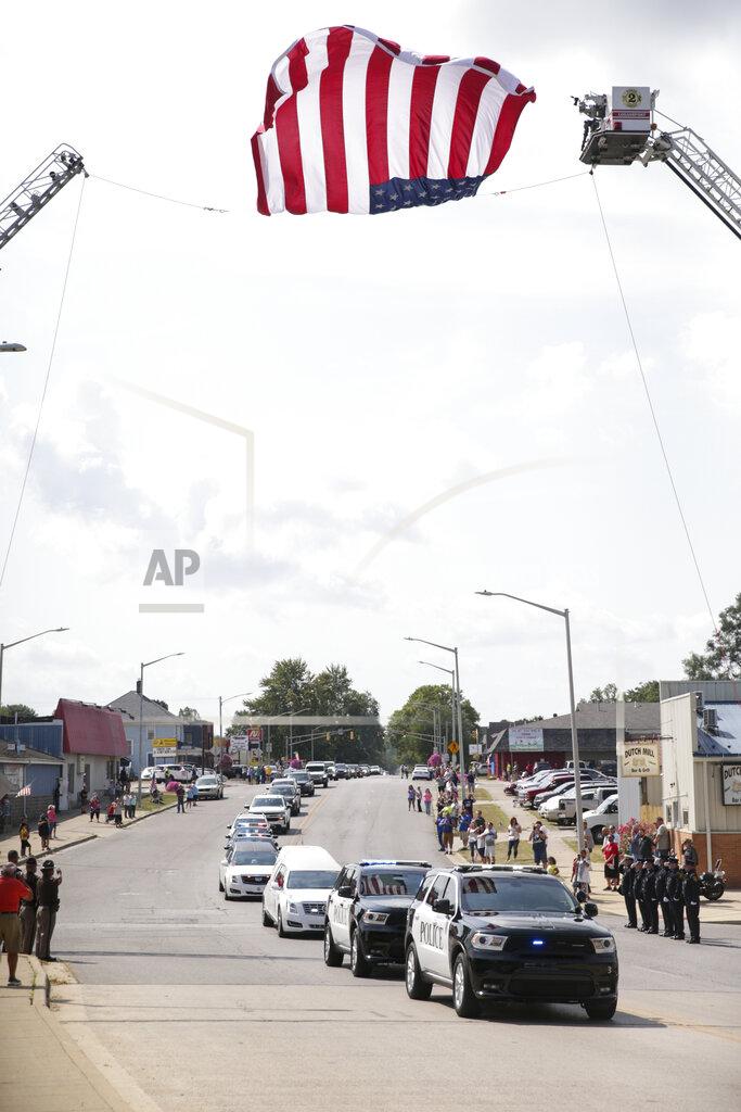 Nikos Frazier The funeral procession for Marine Cpl. Humberto "Bert" Sanchez passes under an American flag, Tuesday, Sept. 14, 2021 in Logansport, Ind. Sanchez was one of 13 U.S. service members to die in an explosion during evacuation efforts in Afghanistan. (Nikos Frazier/Journal & Courier via AP)