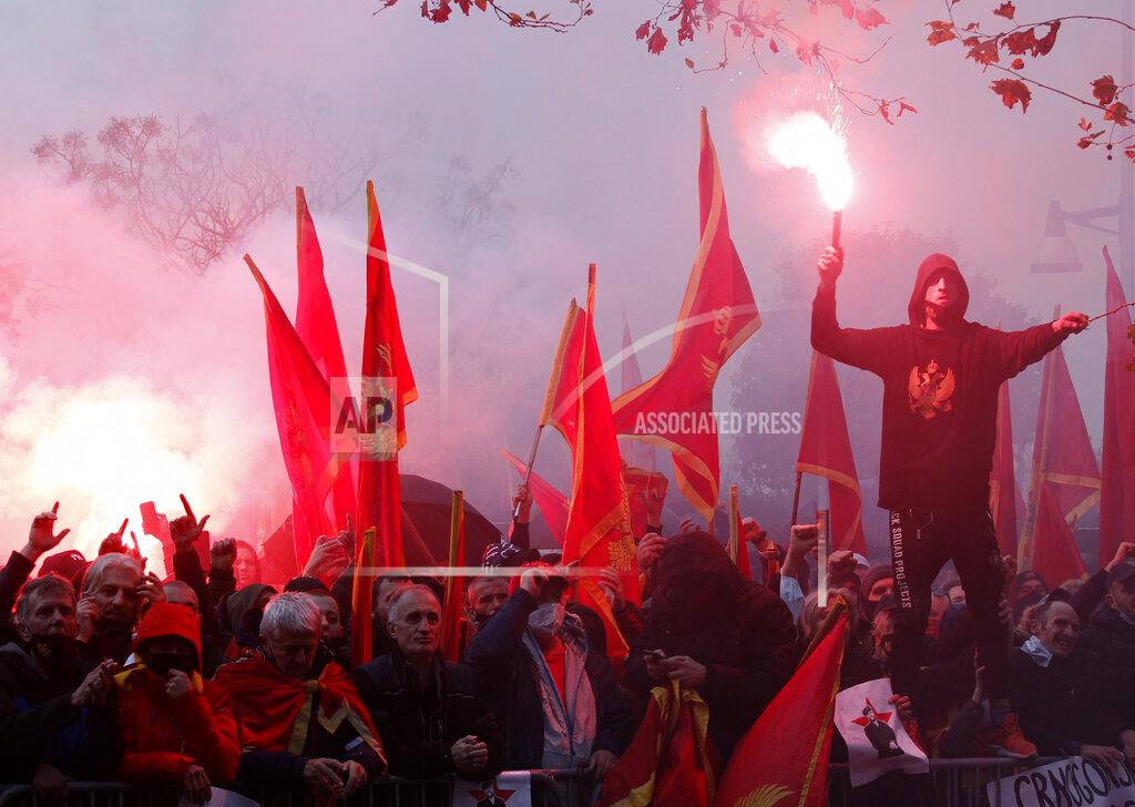 Risto Bozovic People shout slogans during a protest against the new government in Podgorica, Montenegro, Monday, Dec. 28, 2020. Several thousand people rallied Monday in Montenegro, accusing the new government of being pro-Serb because of its plans to amend a religious property law that is strongly opposed by the Serbian Orthodox Church. (AP Photo/Risto Bozovic)
