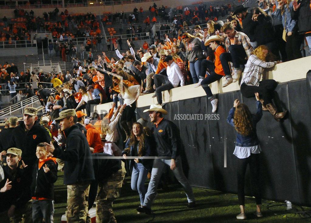 Brody Schmidt Oklahoma State fans stream over the barrier wall and onto the field following an NCAA college football game in Stillwater, Okla., Saturday, Nov. 17, 2018. Oklahoma State upset West Virginia 45-41.(AP Photo/Brody Schmidt)