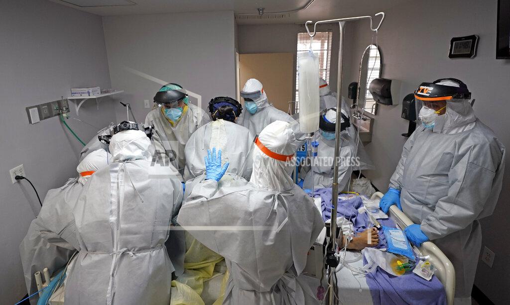David J. Phillip FILE - In this July 6, 2020, file photo, Dr. Joseph Varon, right, leads a team as they try to save the life of a patient unsuccessfully inside the Coronavirus Unit at United Memorial Medical Center, Monday, July 6, 2020, in Houston. The U.S. death toll from the coronavirus topped 200,000 Tuesday, Sept. 22, a figure unimaginable eight months ago when the scourge first reached the world’s richest nation with its sparkling laboratories, top-flight scientists and towering stockpiles of medicines and emergency supplies. (AP Photo/David J. Phillip, File)