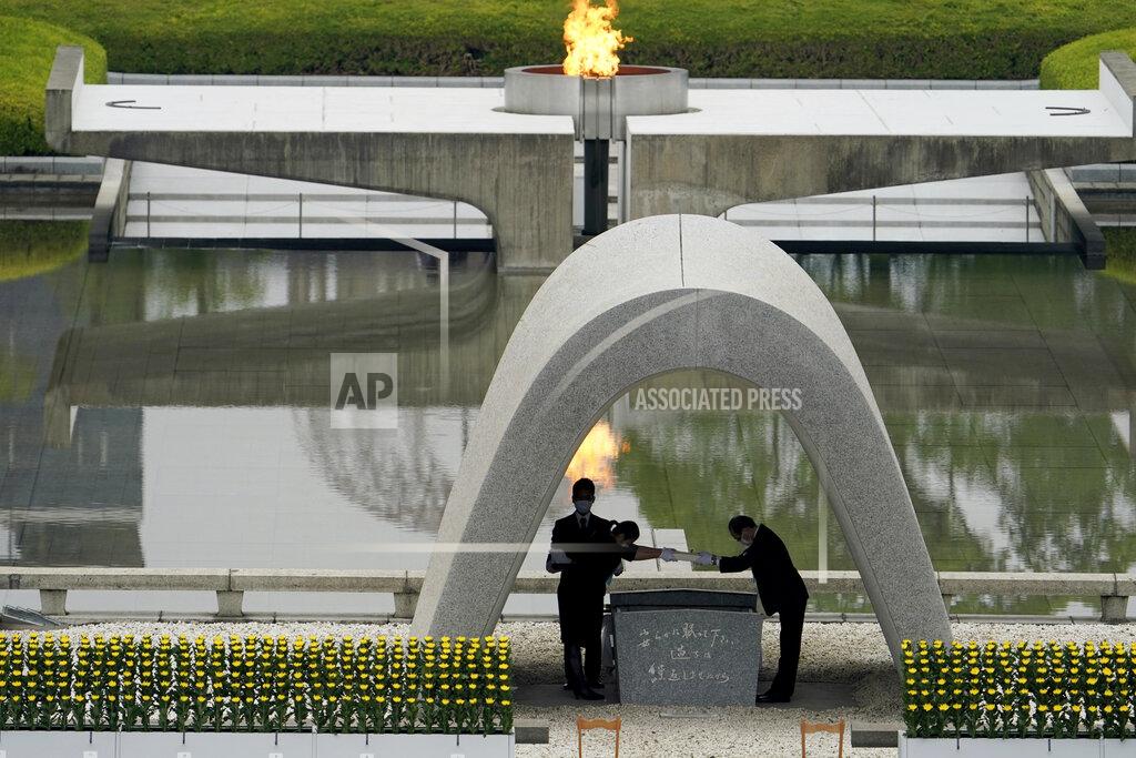 Eugene Hoshiko Kazumi Matsui, right, mayor of Hiroshima, and the family of the deceased bow before they place the victims list of the Atomic Bomb at Hiroshima Memorial Cenotaph during the ceremony to mark the 75th anniversary of the bombing at the Hiroshima Peace Memorial Park Thursday, Aug. 6, 2020, in Hiroshima, western Japan. (AP Photo/Eugene Hoshiko)