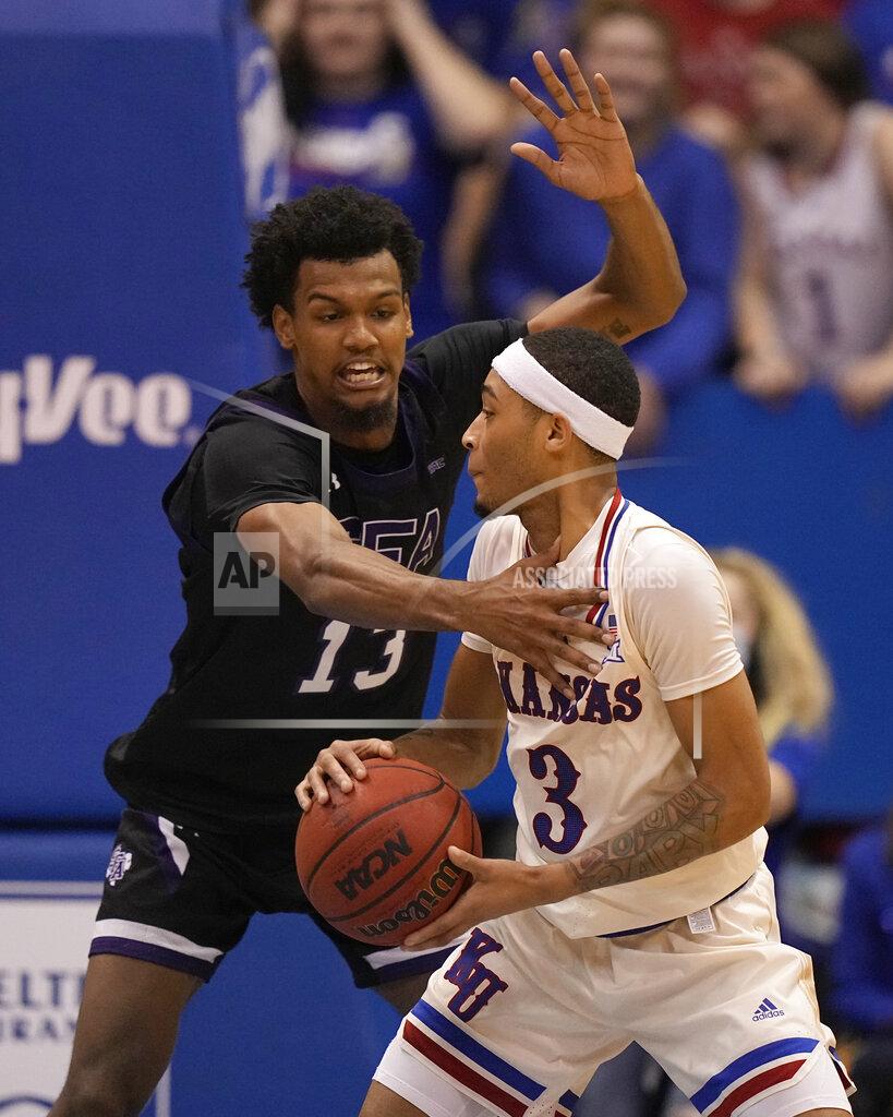 Charlie Riedel Stephen F. Austin's Calvin Solomon (13) tries to steal the ball from Kansas' Dajuan Harris Jr. (3) during the second half of an NCAA college basketball game Saturday, Dec. 18, 2021, in Lawrence, Kan. (AP Photo/Charlie Riedel)