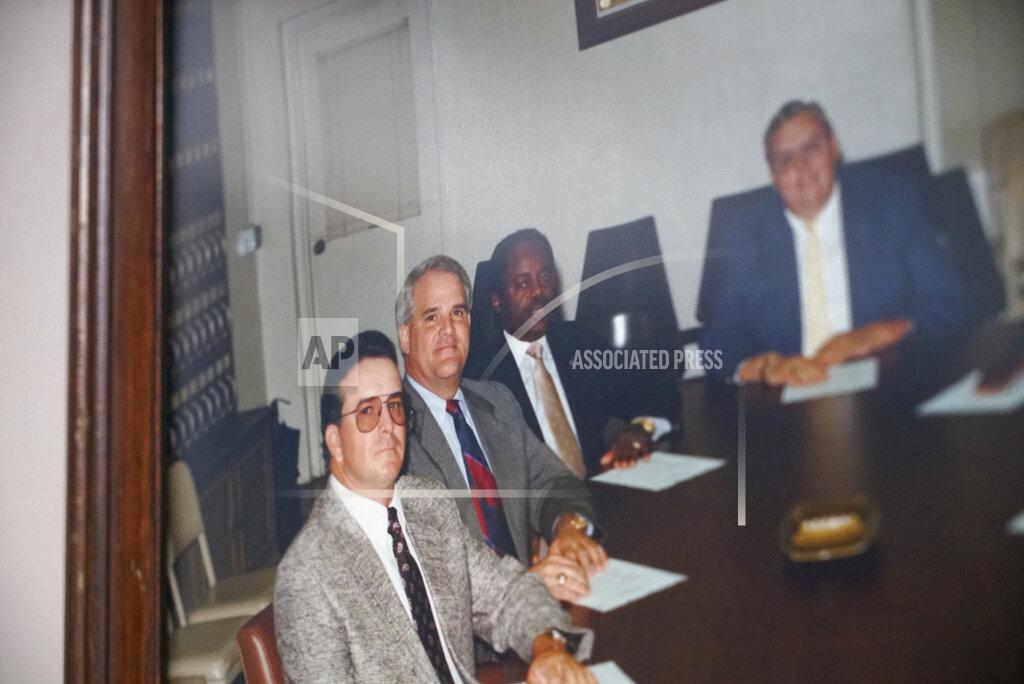 Allen G. Breed A photo of the late William Penn Troy Sr., second from right, and his fellow Marion County Council members, hangs on the wall of his office in Mullins, S.C., on Saturday, May 22, 2021. The funeral director died of COVID-19 in August 2020, one of many Black morticians to succumb during the pandemic. (AP Photo/Allen G. Breed)