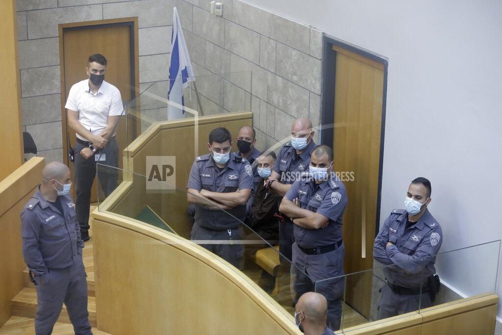Sebastian Scheiner Yakub Kadari is surrounded by guards in a courtroom in Nazareth, Israel, after he and three other Palestinian fugitives were captured on Saturday, Sept. 11, 2021. Israeli police on Saturday said they have arrested four of the six Palestinians who broke out of a maximum-security prison this week — including a famed militant leader whose exploits over the years have made him a well-known figure in Israel. (AP Photo/Sebastian Scheiner)