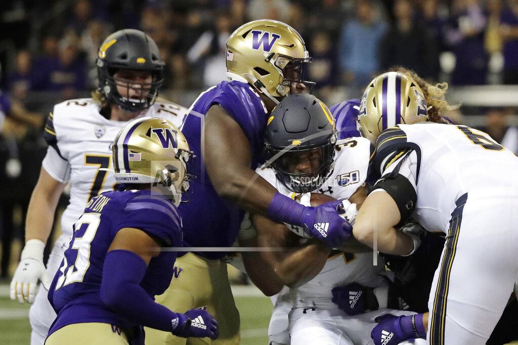 Ted S. Warren California running back Christopher Brown Jr., second from right, is tackled as he carries the ball against Washington during the first half of an NCAA college football game Saturday, Sept. 7, 2019, in Seattle. (AP Photo/Ted S. Warren)
