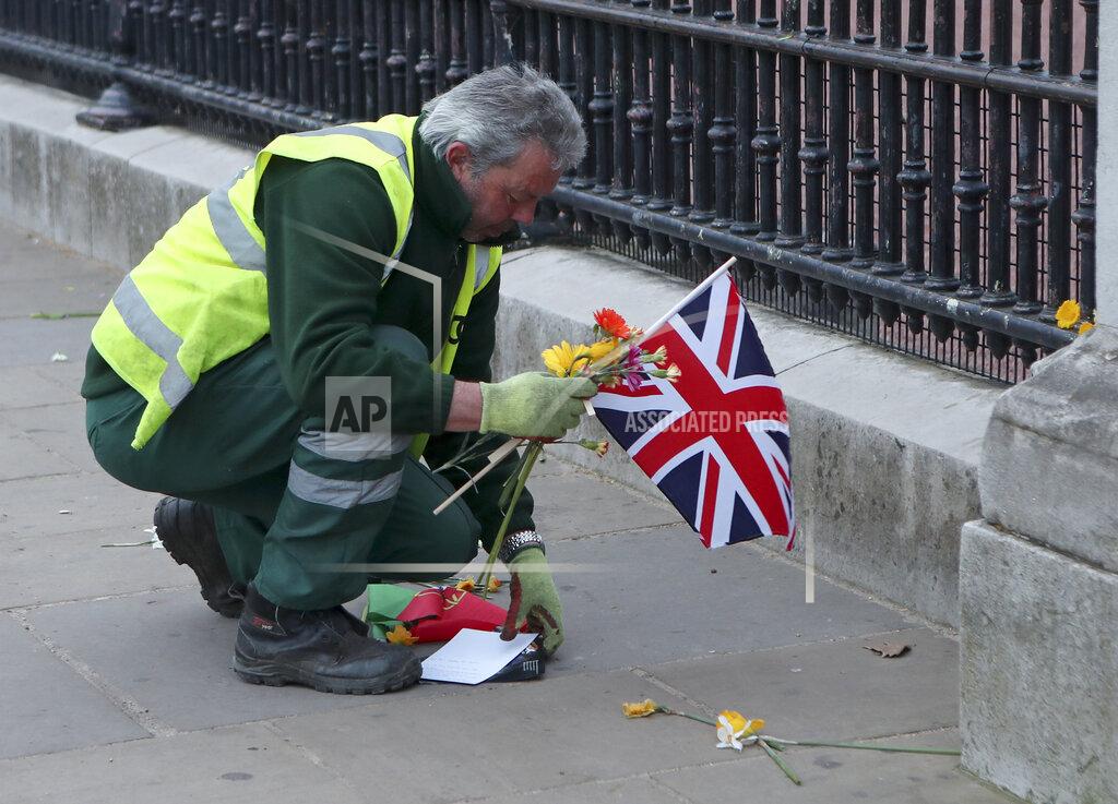 Tony Hicks A worker clears away tributes left in honor of Britain's Prince Philip from outside Buckingham Palace in London on Saturday, April 10, 2021. Prince Philip, the irascible and tough-minded husband of Queen Elizabeth II who spent more than seven decades supporting his wife in a role that both defined and constricted his life, has died, Buckingham Palace said Friday. He was 99. (AP Photo/Tony Hicks)