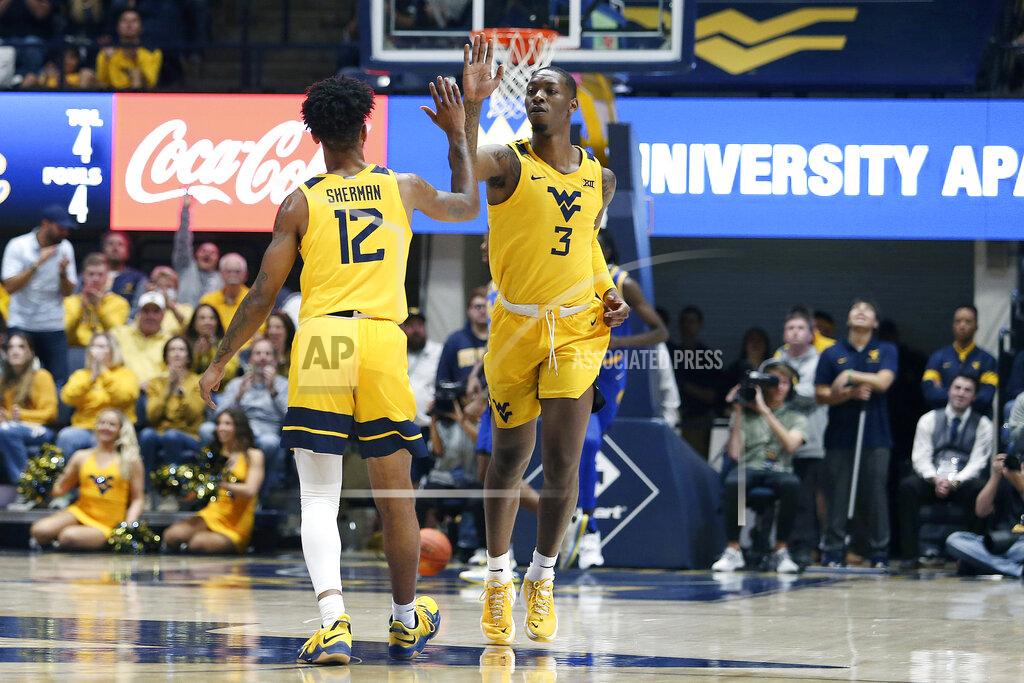 Kathleen Batten West Virginia guard Taz Sherman (12) and forward Gabe Osabuohien (3) celebrate after a score against Pittsburgh during the first half of an NCAA college basketball game in Morgantown, W.Va., Friday, Nov. 12, 2021. (AP Photo/Kathleen Batten)