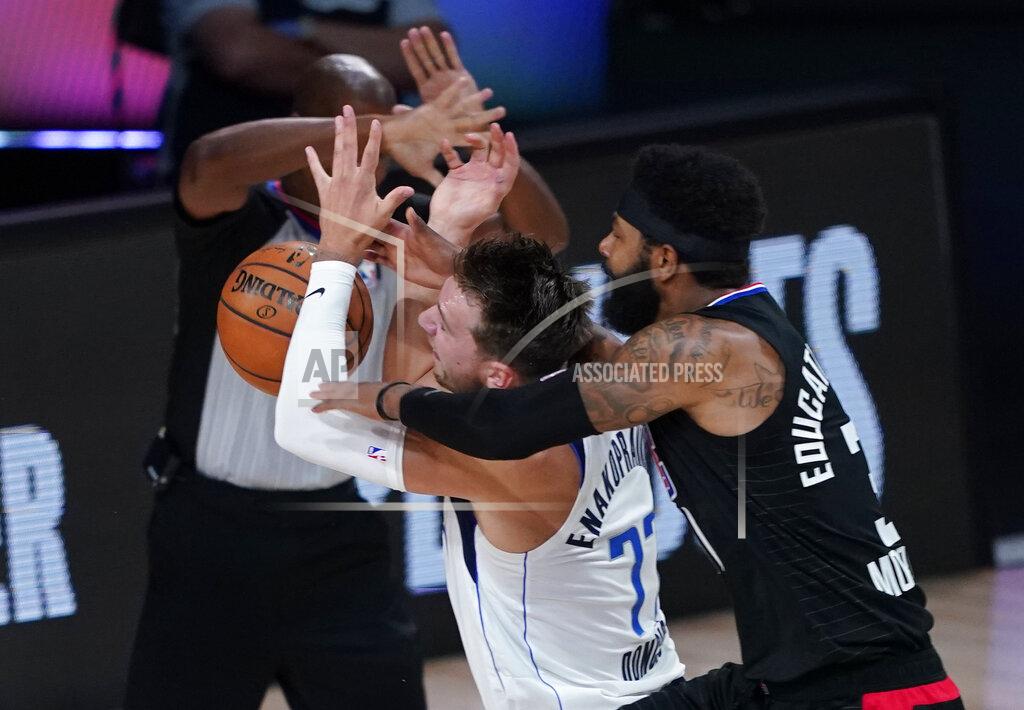 Ashley Landis FILE - In this Aug. 30, 2020, file photo, Dallas Mavericks' Luka Doncic (77) is fouled by Los Angeles Clippers' Marcus Morris Sr. during the first half of an NBA basketball first-round playoff game in Lake Buena Vista, Fla. Doncic's first experience with the playoffs ended with questions about whether Morris was intentionally trying to hurt the young Dallas sensation in a first-round series won by LA. The Mavericks might have hinted at what they thought through trades and draft picks during this abbreviated offseason. Dallas acquired James Johnson and his black belt in karate from the Oklahoma City Thunder after using the club's first-round choice at No. 18 overall on Josh Green, who was a strong defender in his only season at Arizona. (AP Photo/Ashley Landis, File)