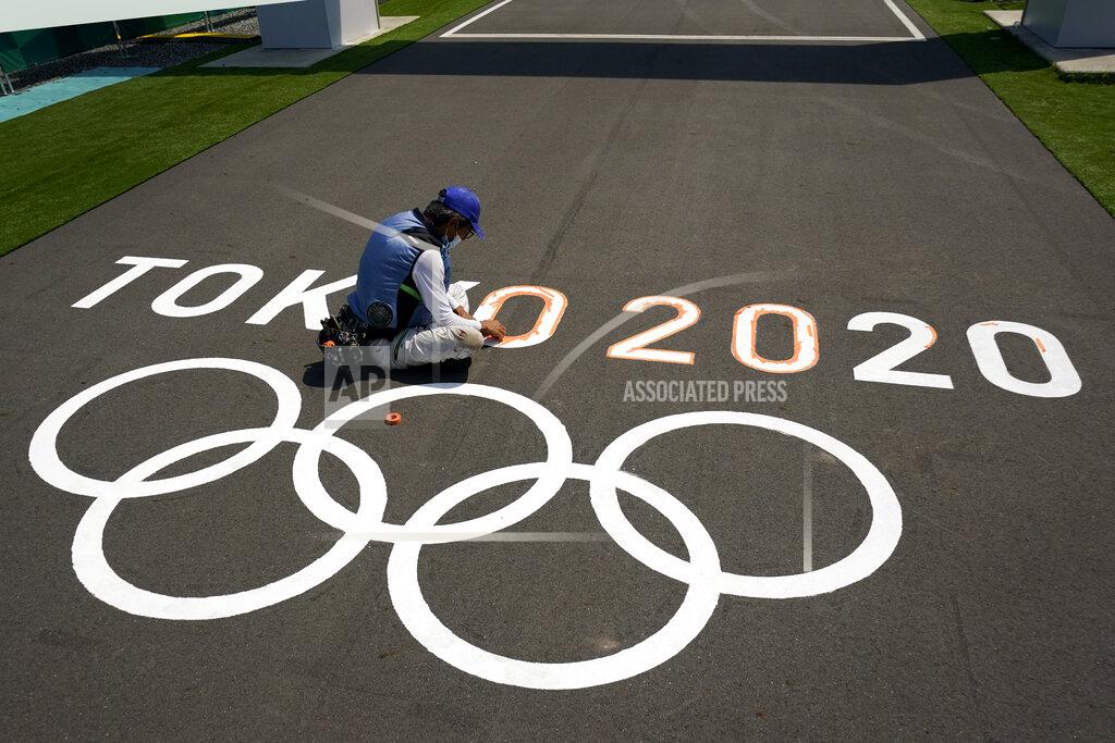 Charlie Riedel A worker paints Olympic rings at the finish line of the BMX racing track as preparations continue for the 2020 Summer Olympics, Tuesday, July 20, 2021, at the Ariake Urban Sports Park in Tokyo. (AP Photo/Charlie Riedel)