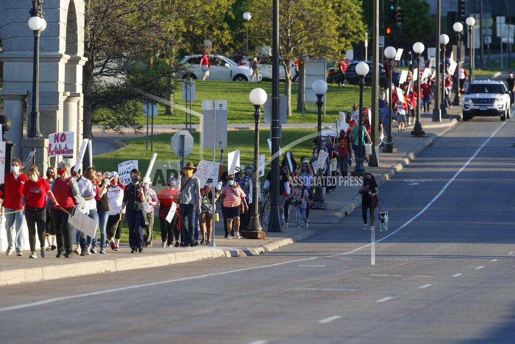 Jim Mone Nurses march to the Minnesota State Capitol after picketing at United Hospital Wednesday, May 20, 2020 in St. Paul, Minn. as they seek a say in worker protections, increased personal protection resources with higher safety standards, and an end to retaliation against workers who have tried to protect themselves from the COVID-19 virus. (AP Photo/Jim Mone)