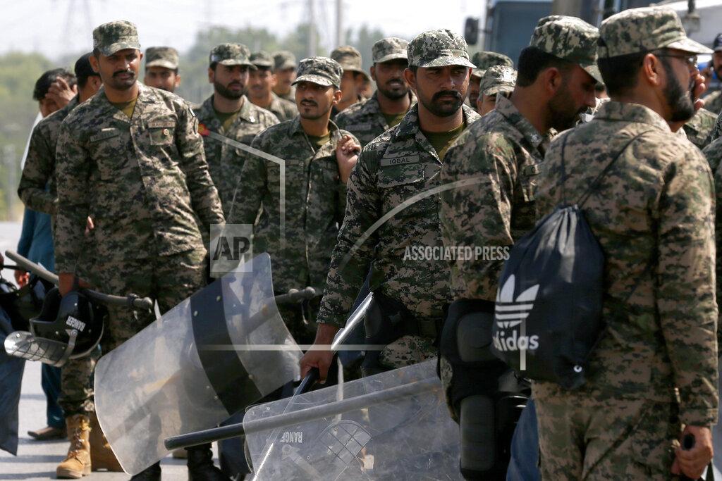 Anjum Naveed Paramilitary soldiers with riot gears arrive to take position at an entry point to capital city in an attempt to foil a planned rally, in Islamabad, Pakistan, Wednesday, May 25, 2022. Pakistani authorities blocked off all major roads into the capital Islamabad on Wednesday, after a defiant former Prime Minister Imran Khan said he would march with demonstrators to the city center for a rally he hopes will bring down the government and force early elections.(AP Photo/Anjum Naveed)