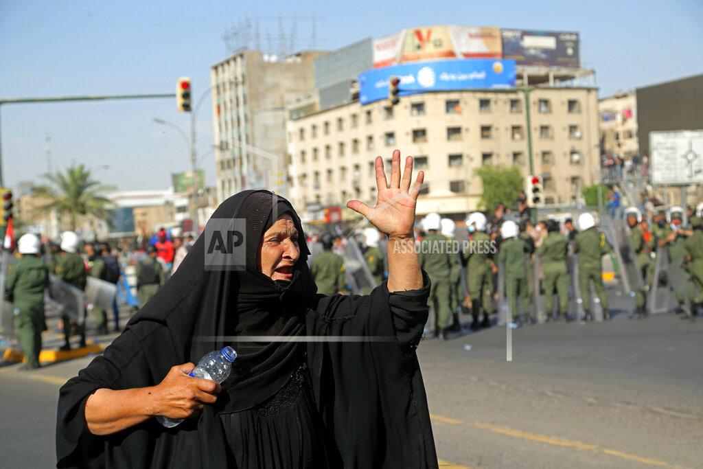 Hadi Mizban A woman chants slogans while security forces try to disperse the anti-government protesters, in Tahrir Square, Baghdad, Iraq, Tuesday, May 25, 2021. Hundreds of Iraqis took to the streets in Baghdad on Tuesday to protest what they say is impunity by those behind a rising number of targeted killings of prominent activists and journalists. (AP Photo/Hadi Mizban)