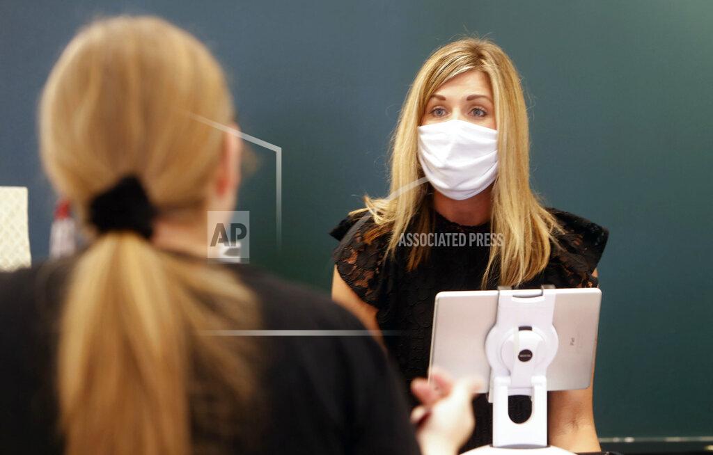In this Wednesday, May 13, 2020, photo, Amy Witt, right, owner of the Velvet Window, talks with store customer Monique Kursar, in Dallas. Small businesses are navigating a new way to work with customers amid concerns of the spread of the coronavirus. (AP Photo/LM Otero)