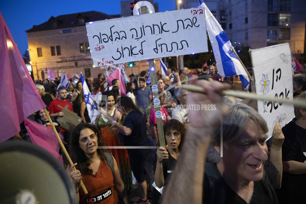 Ariel Schalit Israeli protesters march with a signs that reads "Bibi , last Saturday in Balfour start packing " during a demonstration against Israeli Prime Minister Benjamin Netanyahu outside his official residence in Jerusalem, Saturday, June 12, 2021. If all goes according to plan, Israel will swear in a new government on Sunday, ending Prime Minister Benjamin Netanyahu's record 12-year rule and a political crisis that inflicted four elections on the country in less than two years. (AP Photo/Ariel Schalit)