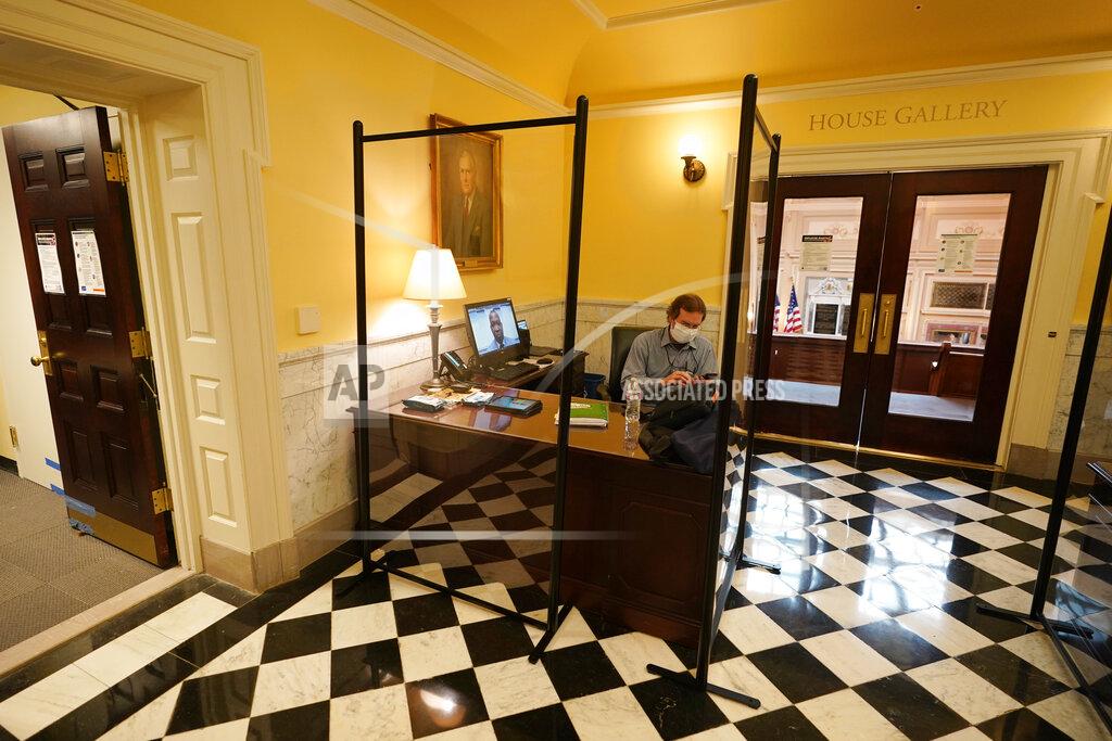 Steve Helber House telecommunications coordinator, Aubrey Stewart, monitors a Virginia House of Delegates Zoom Legislative meeting from the Gallery at the Capitol in Richmond, Va., Wednesday, Feb. 10, 2021. (AP Photo/Steve Helber)