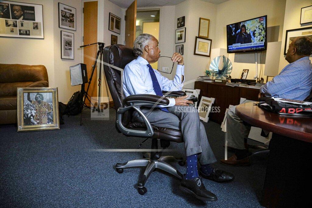Bebeto Matthews The Rev. Al Sharpton, left, sits in his office along with attorney Michael Hardy, right, watching the funeral service for Rep. John Lewis at his office, Thursday, July 30, 2020, in New York. For more than three decades, Sharpton, 65, has been an advocate for Black American families seeking justice in the wake of violence that highlight systemic racism.(AP Photo/Bebeto Matthews)
