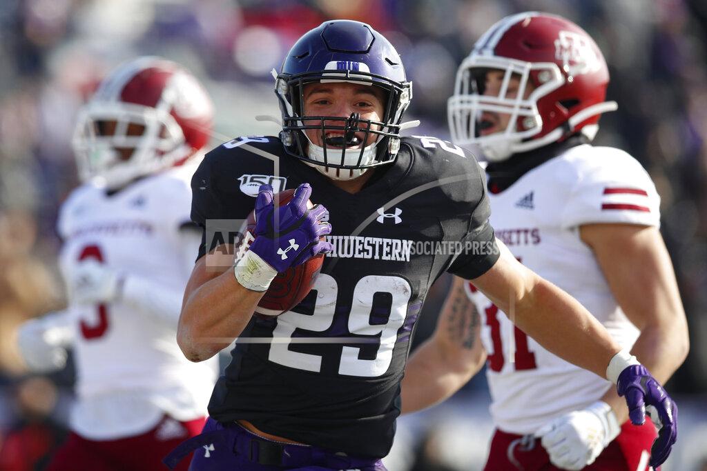 Jim Young Northwestern's Evan Hull, center, celebrates as he scores a touchdown past Massachusetts' Isaiah Rodgers, left, and Massachusetts' Logan Darby during the first half of an NCAA college football game Saturday, Nov. 16, 2019, in Evanston, Ill. (AP Photo/Jim Young)