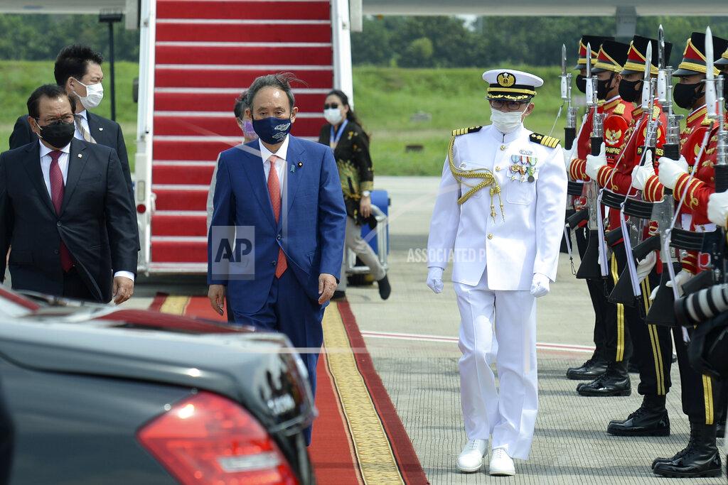 Uncredited In this photo released by Indonesian Presidential Palace, Japanese Prime Minister Yoshihide Suga, center, walks to his car upon arrival at Halim Perdanakusuma Airport in Jakarta, Indonesia, Tuesday, Oct. 20, 2020. Suga arrived in Indonesia on the second leg of his first overseas trip as premier to underscore his government’s aims of countering China in the region. (Indonesian Presidential Palace via AP)