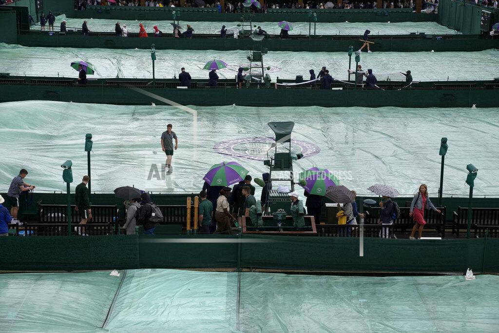 Alastair Grant Rain covers are placed on the courts on day one of the Wimbledon tennis championships in London, Monday, June 27, 2022. (AP Photo/Alastair Grant)
