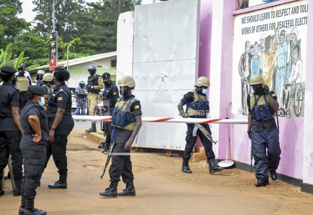 Ronald Kabuubi Security forces guard the entrance to the Electoral Commission during a visit by Ugandan opposition presidential candidate Bobi Wine in Kampala, Uganda Wednesday, Dec. 2, 2020. Wine said Wednesday after meeting the head of the country's electoral body that he would resume his campaign after suspending it in protest over police brutality after police shot his car tires and fired rubber bullets that injured his bodyguards and supporters. (AP Photo/Ronald Kabuubi)