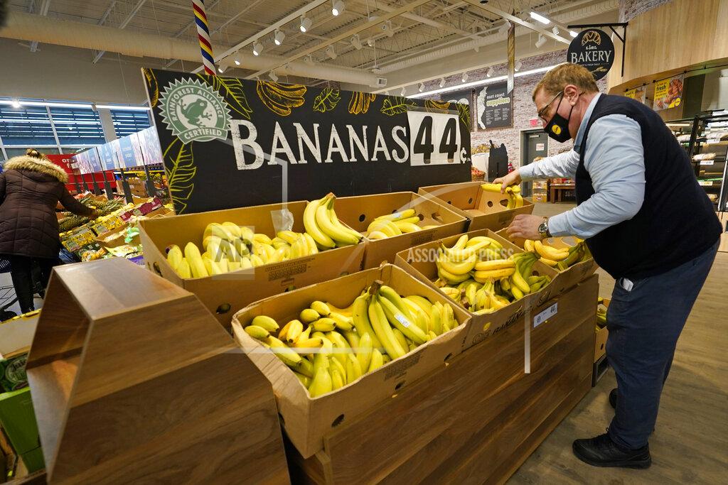 Kathy Willens Lidl employee Joseph Lupo, arranges bananas in the produce aisle of the market where he works, Thursday, Feb. 4, 2021, in Lake Grove, N.Y. Earlier in the day, Lupo received the first dose of the coronavirus vaccine. The German grocery chain is offering $200 to any employee who gets vaccinated as an incentive. Lupo, who fell ill with the virus in March, was elated to get his first vaccine dose. "I never ever want to get COVID again, or see anybody else get it," said Lupo, 59. (AP Photo/Kathy Willens)