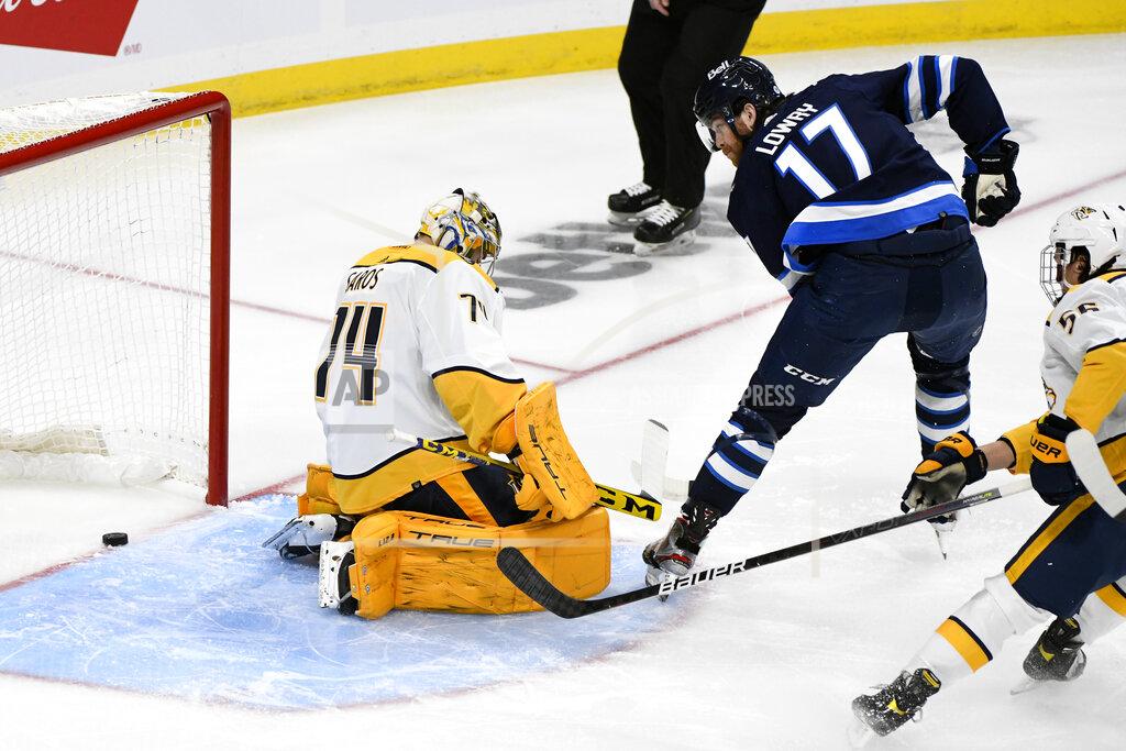 Fred Greenslade Winnipeg Jets' Adam Lowry (17) scores against Nashville Predators goaltender Juuse Saros (74) during the first period of NHL hockey game action in Winnipeg, Manitoba, Saturday, Oct. 23, 2021. (Fred Greenslade/The Canadian Press via AP)