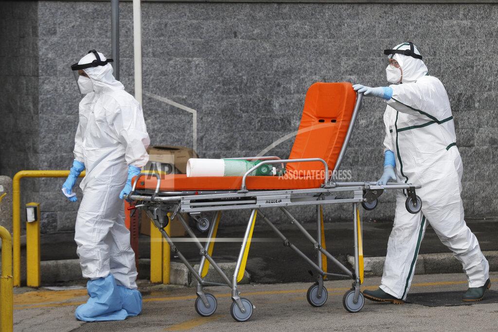 Gregorio Borgia An oxygen canister is carried on a stretcher by paramedics boarding an ambulance, outside the first aid department of the Cardarelli hospital in Naples, Italy, Friday, Nov. 13, 2020. Outside the ER entrance of Cardarelli, the main health care facility for densely populated Naples, those desperate for oxygen for loved ones lined up in their cars, waiting for nurses to bring tanks of the life-saving element. (AP Photo/Gregorio Borgia)