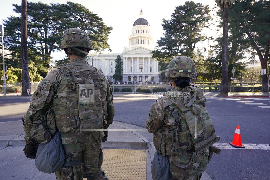 Rich Pedroncelli Members of the California National Guard walk past the California state Capitol in Sacramento, Calif., Wednesday, Jan. 20, 2021. A temporary 6-foot high chain link fence surrounds the Capitol and California Gov. Gavin Newsom mobilized the National guard last week over concerns that protests around the inauguration of President Joe Biden could turn violent and destructive. (AP Photo/Rich Pedroncelli)
