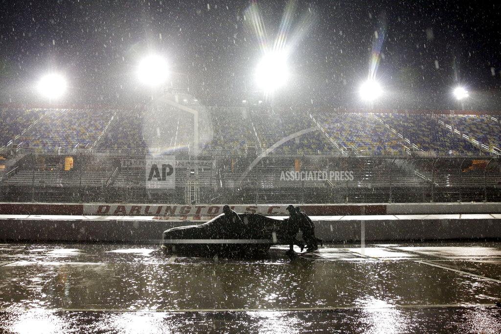 A crew pushes a car through the pit area at Darlington Raceway after the NASCAR Xfinity series auto race was postponed because of rain on May 19, 2020, in Darlington, S.C. (AP Photo/Brynn Anderson)