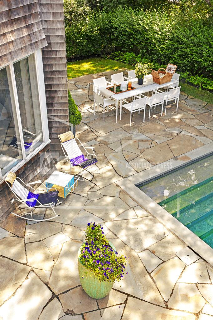 This photo provided by Rottet Studio shows a backyard designed by architect and interior designer Lauren Rottet in Montauk, N.Y. To add color and a lovely scent, Rottet recommends adding a large planter filled with flowering plants, as she did here in this backyard. (Eric Laignel/Rottet Studio via AP)