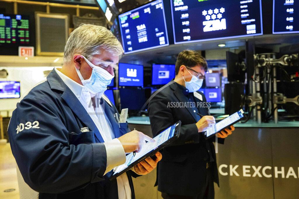 In this photo provided by the New York Stock Exchange, a pair of traders work on the floor, Tuesday Feb. 2, 2021. Stocks were broadly higher in afternoon trading Tuesday, but shares of closely watched companies like GameStop and AMC Entertainment were falling sharply. (Colin Ziemer/New York Stock Exchange via AP)