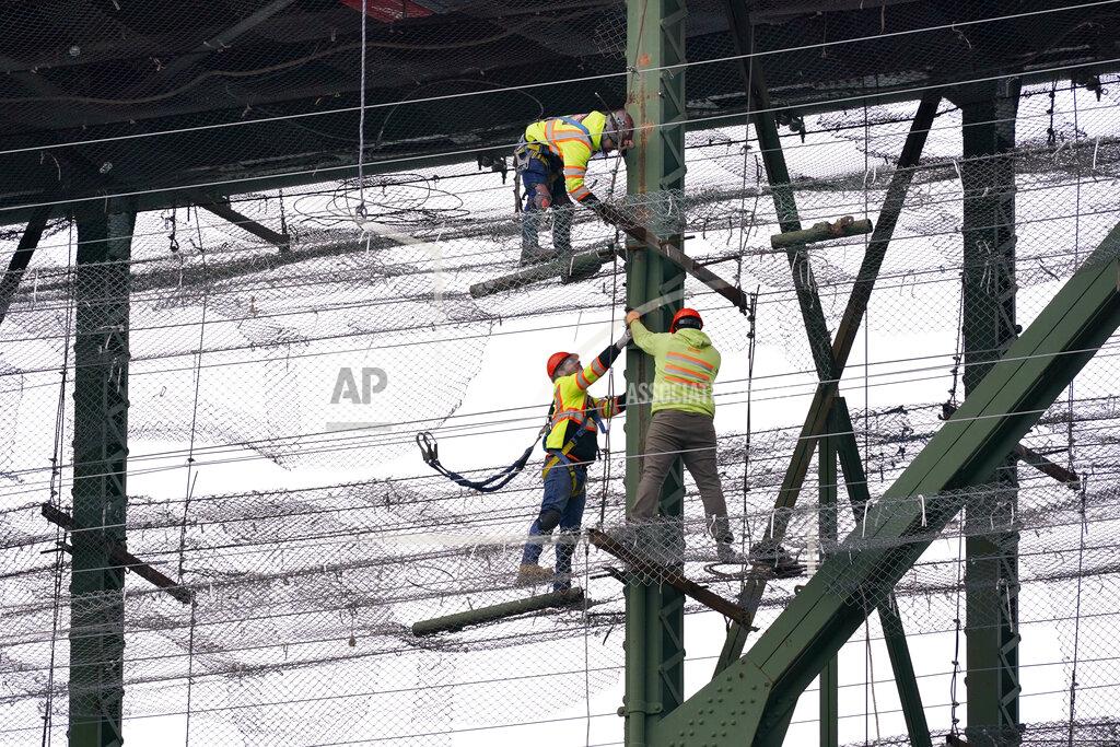 Elaine Thompson Workers stand on wire mesh below the decking of the Deception Pass Bridge, nearly 1,000-feet long and about 180-feet above the waters below, as work to replace corroded steel and paint the structure continues Thursday, April 29, 2021, in Deception Pass, Wash. Raising state taxes to improve roads and bridges is one of the few things many Republican and Democratic lawmakers have agreed on in recent years. Those efforts have slowed to a crawl this year, even as lawmakers acknowledge a widening gap between needed work and the money to pay for it. (AP Photo/Elaine Thompson)