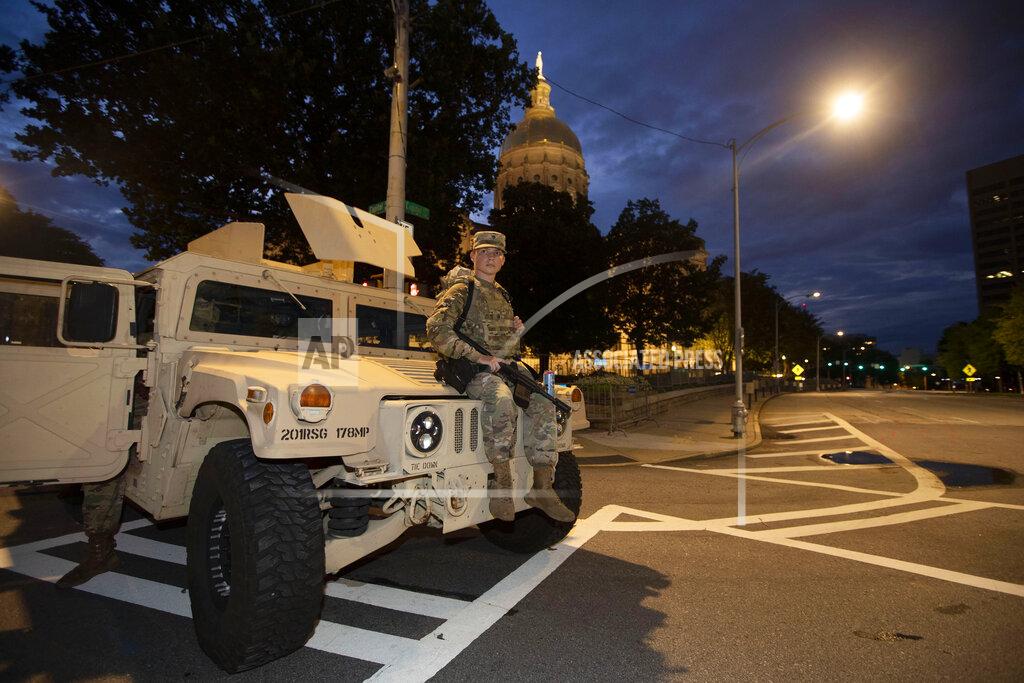 John Bazemore A member of the Georgia National Guard sits on a vehicle outside the State Capitol on Tuesday, July 7, 2020, in Atlanta. Georgia Gov. Brian Kemp mobilized the guard after an increase in gun violence over the weekend. (AP Photo/John Bazemore)