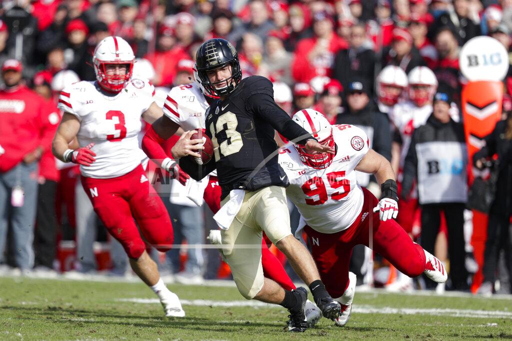 Michael Conroy Purdue quarterback Jack Plummer (13) slides to a gain in front of Nebraska linebacker Will Honas (3) and defensive lineman Ben Stille (95) during the first half of an NCAA college football game in West Lafayette, Ind., Saturday, Nov. 2, 2019. (AP Photo/Michael Conroy)