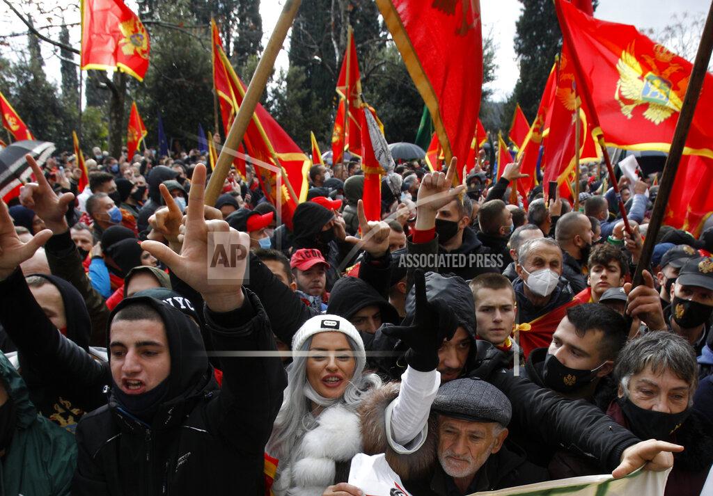 Risto Bozovic People shout slogans during a protest against the new government in Podgorica, Montenegro, Monday, Dec. 28, 2020. Several thousand people rallied Monday in Montenegro, accusing the new government of being pro-Serb because of its plans to amend a religious property law that is strongly opposed by the Serbian Orthodox Church. (AP Photo/Risto Bozovic)