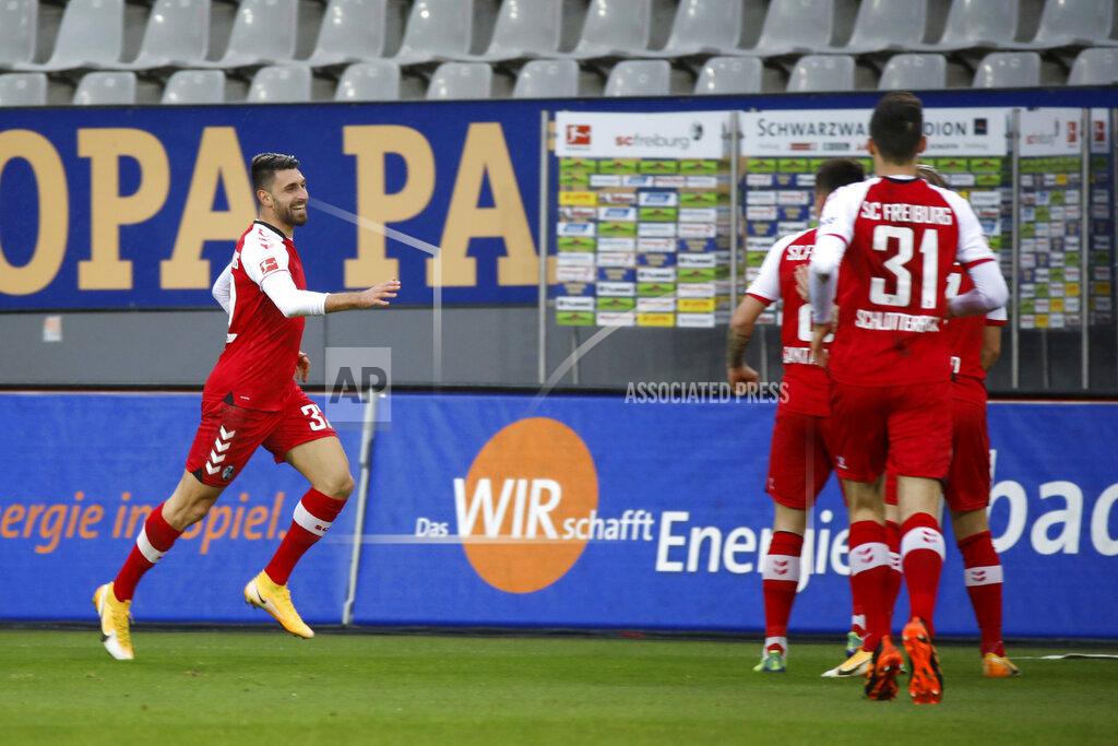 Philipp Von Ditfurth Vincenzo Grifo, left, of SC Freiburg celebrates after scoring the opening goal during the Bundesliga soccer match between SC Freiburg and Hertha BSC Berlin in Freiburg, Germany, Sunday, Dec. 20, 2020. (Philipp von Ditfurth/dpa via AP)