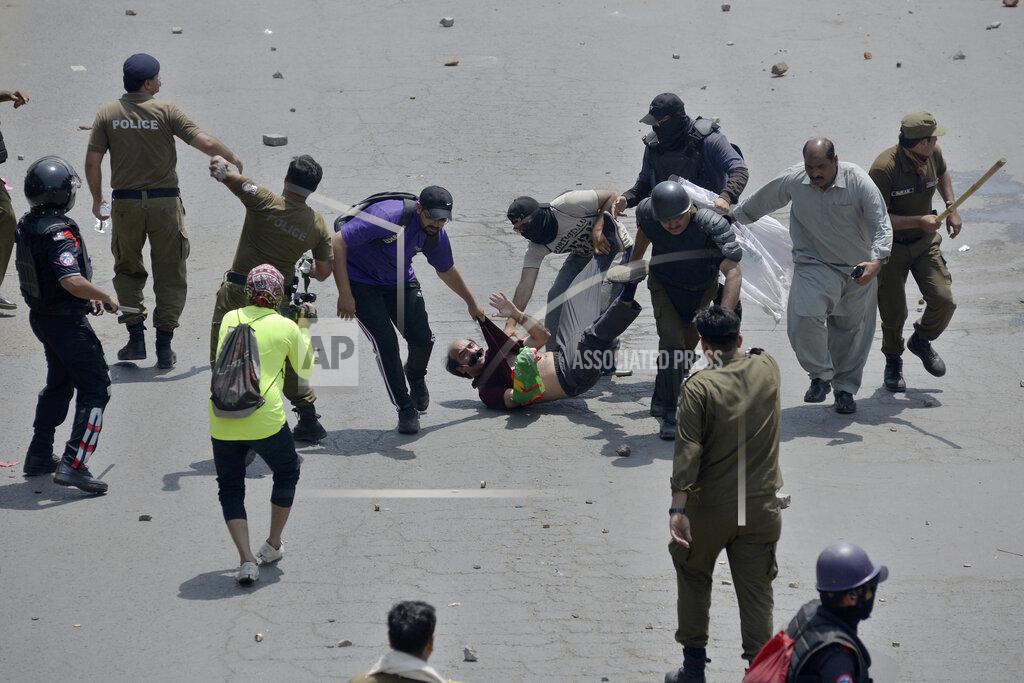 K.M. Chaudary Police officers detain a supporter of Pakistan's key opposition as clashes broke out during a protest march toward Islamabad, in Lahore, Pakistan, Wednesday, May 25, 2022. Pakistani authorities blocked off all major roads into the capital Islamabad on Wednesday, after a defiant former Prime Minister Imran Khan said he would march with demonstrators to the city center for a rally he hopes will bring down the government and force early elections. (AP Photo/K.M. Chaudary)