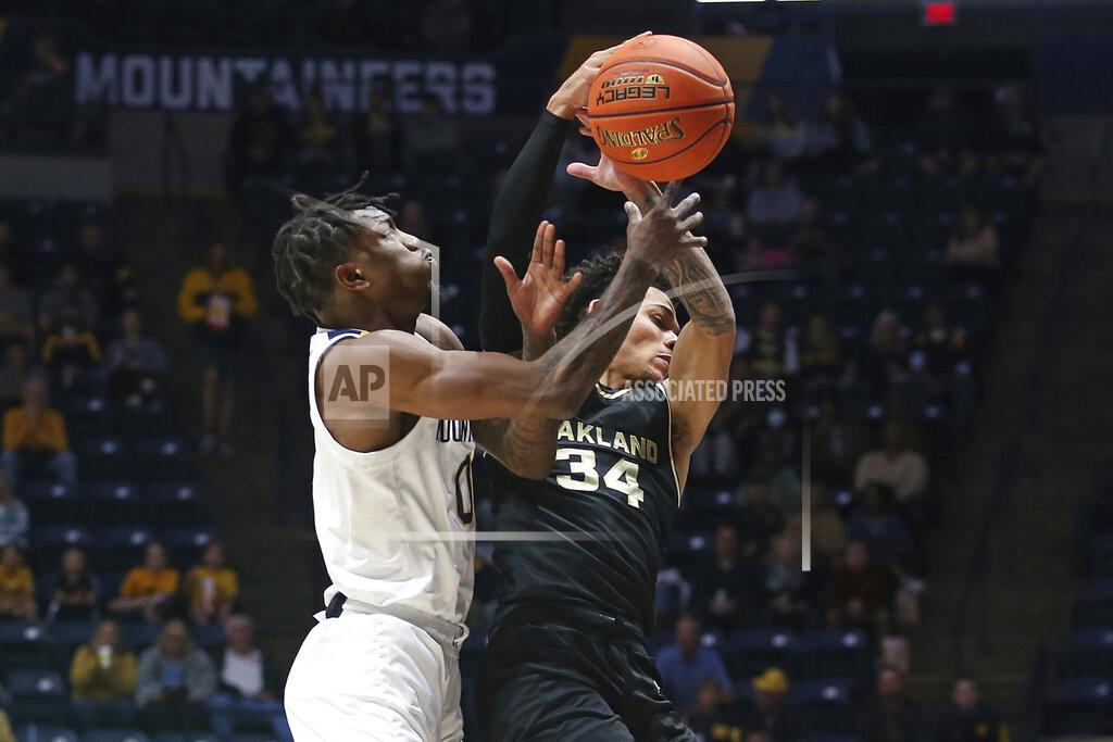 Kathleen Batten Oakland guard Jalen Moore (34) is defended by West Virginia guard Kedrian Johnson (0) during the first half of an NCAA college basketball game in Morgantown, W.Va., Tuesday, Nov. 9, 2021. (AP Photo/Kathleen Batten)