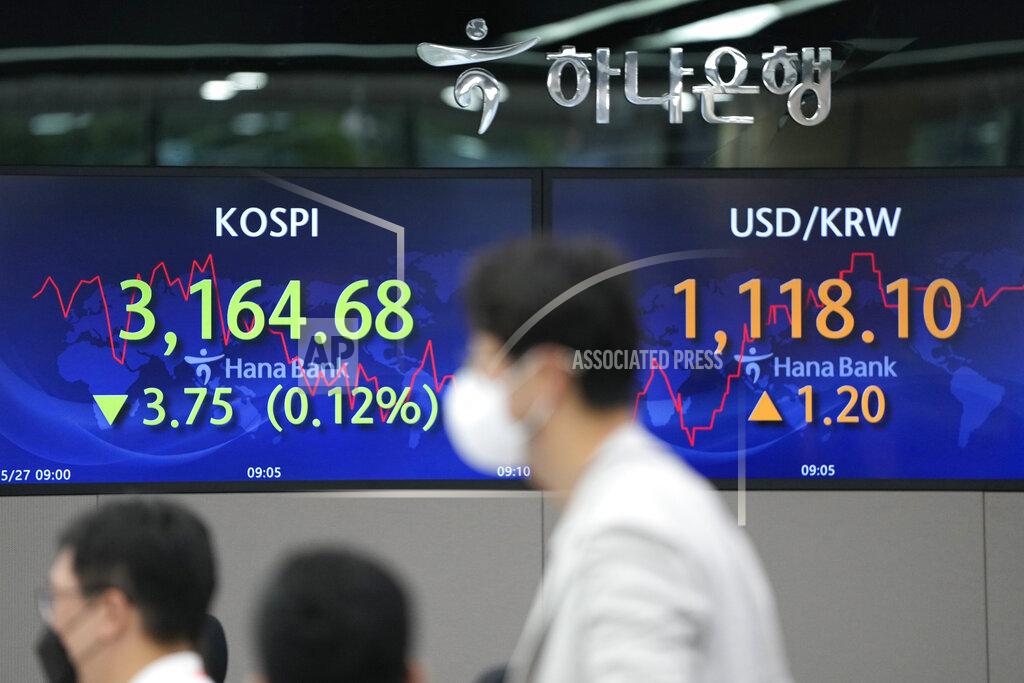 Lee Jin-Man Currency traders watch computer monitors near the screens showing the Korea Composite Stock Price Index (KOSPI), left, and the foreign exchange rate between U.S. dollar and South Korean won at the foreign exchange dealing room in Seoul, South Korea, Thursday, May 27, 2021. Asian shares fell Thursday, as investors watched for signs of inflation and awaited U.S. economic data expected later in the day. (AP Photo/Lee Jin-man)