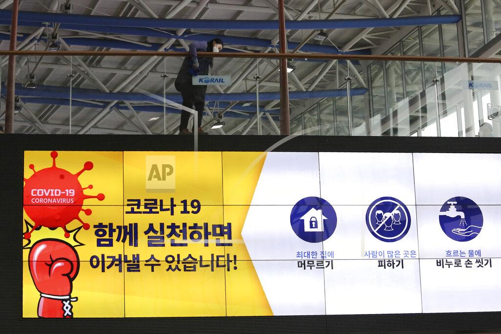Ahn Young-Joon A worker cleans glasses on a screen showing precautions against the new coronavirus at the Seoul Railway Station in Seoul, South Korea, Saturday, May 2, 2020. South Korea reported fresh cases of the new coronavirus are continuing a month-long downturn. The sign reads: "Corona 19. If we practice together, we can overcome." (AP Photo/Ahn Young-joon)