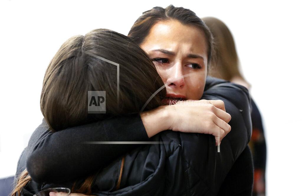 Paul Sancya Bailey Kowalski hugs a friend before a news conference in East Lansing, Mich., Thursday, April 11, 2019. The 22-year-old Michigan State University student is speaking publicly a year after suing the school, alleging that three former men's basketball players raped her in 2015 and that she was discouraged by counseling center staff from reporting what happened. (AP Photo/Paul Sancya)