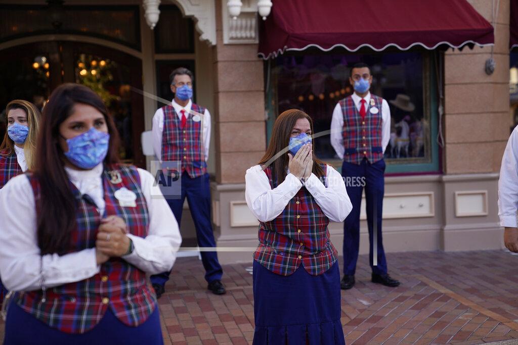 Jae Hong Employees hold a meeting before the gates open at Disneyland in Anaheim, Calif., Friday, April 30, 2021. The iconic theme park in Southern California that was closed under the state's strict virus rules swung open its gates Friday and some visitors came in cheering and screaming with happiness. (AP Photo/Jae Hong)