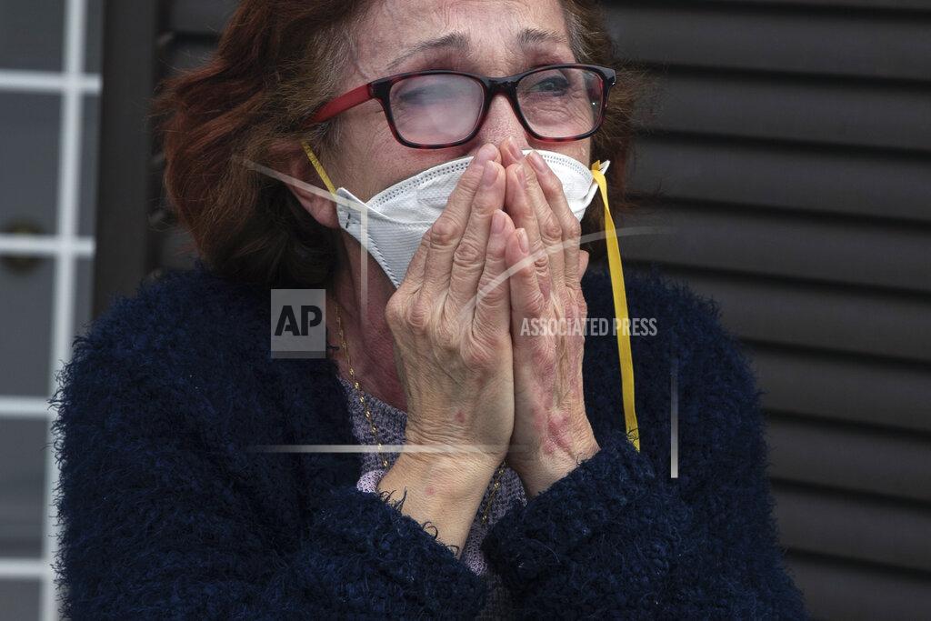 Manu Fernandez A woman wearing a face mask cries during her granddaughter Lucia's 12th birthday celebration while her parents are working, at her home during the lockdown to combat the spread of coronavirus in Grinon, Spain, Friday, April 17, 2020. Spain has eased this week the conditions of Europe's strictest lockdown, allowing manufacturing, construction and other nonessential activity in an attempt to cushion the economic impact of the pandemic. (AP Photo/Manu Fernandez)