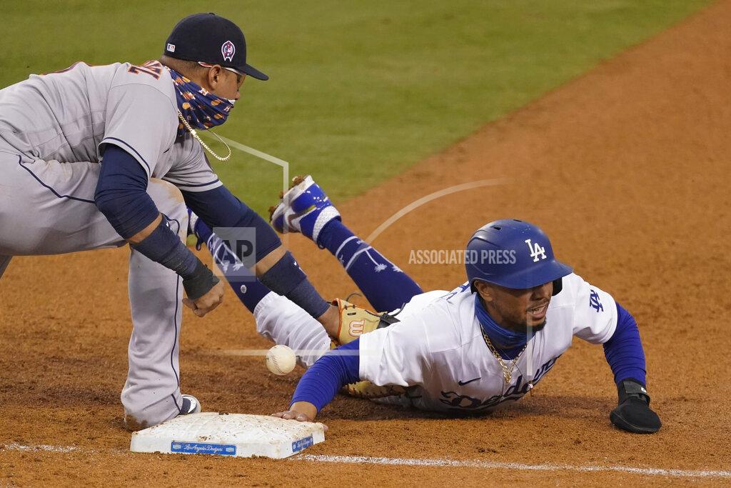 Ashley Landis Houston Astros first baseman Yuli Gurriel, left, loses control of the ball as Los Angeles Dodgers' Mookie Betts, right, dives back to first base during the fifth inning of a baseball game Saturday, Sept. 12, 2020, in Los Angeles. (AP Photo/Ashley Landis)