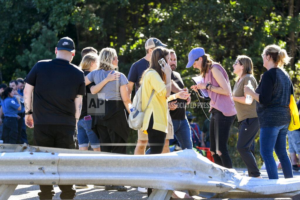 Jacqueline Dormer People gather at the scene after a Premiere #1 Limousine bus crashed into a wooded area off I-81 in Frailey Township, Pa., on Sunday, Sept. 19, 2021. The bus was traveling on I-81 south and came off the Hegins exit ramp, crossing through the divider on Rt. 25 and crashing into a wooded area off Rt. 25 where it came to a stop. (Jacqueline Dormer/Republican-Herald via AP)