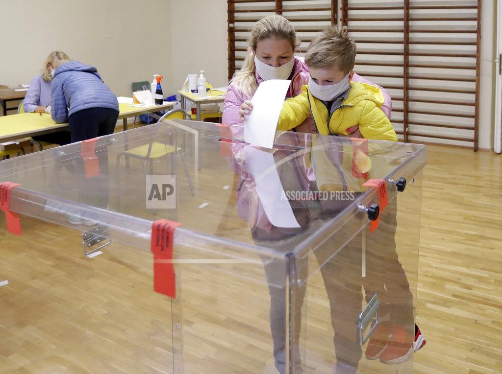 Petr David Josek A woman with her son cast a vote during presidential runoff election in Krakow, Poland, Sunday, July 12, 2020. Polish President Andrzej Duda and Warsaw Mayor Rafal Trzaskowski are heading into a tight presidential runoff that is seen as an important test for populism in Europe. The Sunday, July 12 election comes after a bitter campaign that has exacerbated a conservative-liberal divide in the country. (AP Photo/Petr David Josek)