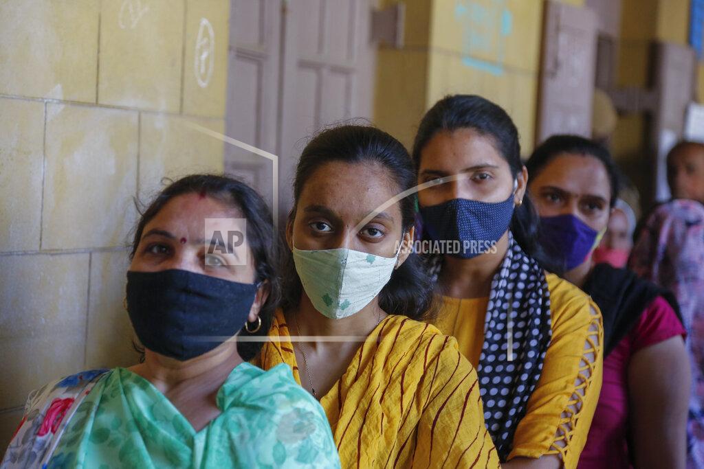 Ajit Solanki Indian women wearing face masks as precaution against COVID-19, stand in queue to cast their vote for local body elections in Ahmedabad, India, Sunday, Feb. 21, 2021. (AP Photo/Ajit Solanki)