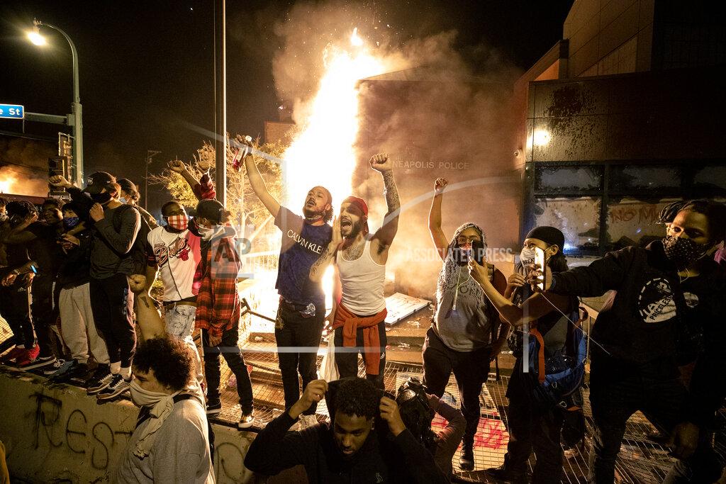 Carlos Gonzalez People stand outside the Minneapolis police 3rd Precinct building after fires were set at the building, Thursday, May 28, 2020, in Minneapolis, during demonstrations over the death George Floyd on Monday in Minneapolis police custody. (Carlos Gonzalez/Star Tribune via AP)