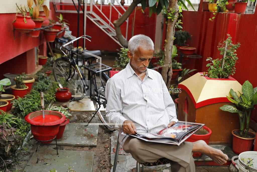 Rajesh Kumar Singh Radha Gobindo Pramanik looks through a family album while sitting in his yard in Lucknow, India, Thursday, June 3, 2021. Pramanisk's wife, his daughter and his unborn grandchild succumbed to the coronavirus along with tens of thousands of others as it ravaged the country in April and May. As India emerges from its darkest days of the pandemic, families across the country are grieving all that they’ve lost and are left wondering if more could have been done to avoid this tragedy. (AP Photo/Rajesh Kumar Singh)