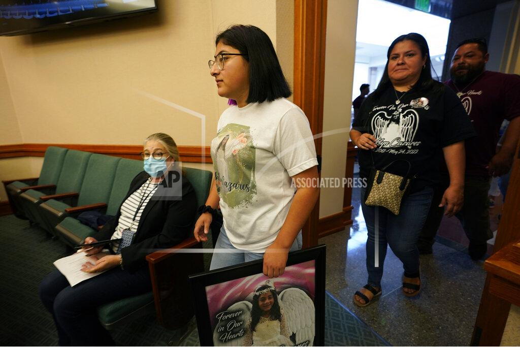 Eric Gay Jazmin Cazares carries a photos of her young sister Jacklyn, who was one of 19 children killed at Robb Elementary School, as she arrives for a hearing at the state capitol, Thursday, June 23, 2022, in Austin, Texas. Cazares pleaded for Texas lawmakers to pass gun safety legislation and questioned why so many security measures failed. (AP Photo/Eric Gay)